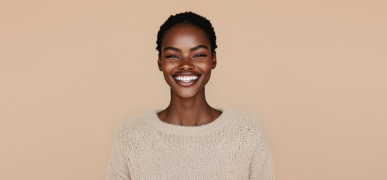 Smiling young afro model in beige sweater on one tone background. Fall winter concept.