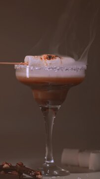 s'mores cocktail with toasted marshmallow in fire and with smoke