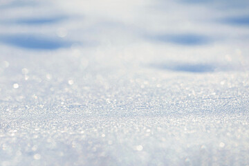Winter christmas background - view of the snowdrift sparkling in the rays of the winter sun, selective focus
