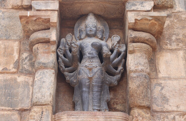 The multi-handed sculpture is carved into a thousand-year-old temple wall.