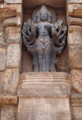 The multi-handed sculpture is carved into a thousand-year-old temple wall.