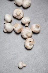 Raw mini mushroom champignon in a gray background. Top view