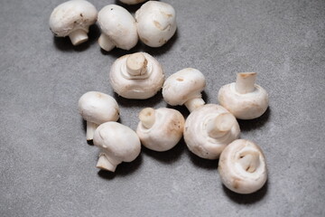 Raw mini mushroom champignon in a gray background. Top view