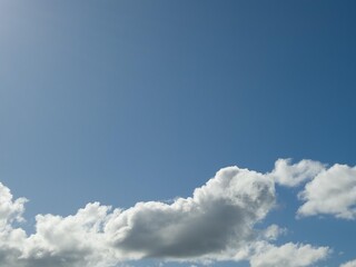 Summer white fluffy cumulus clouds in the deep blue sky