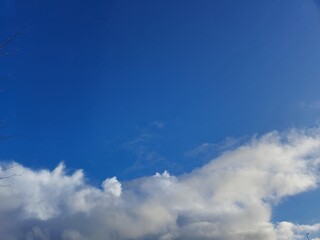 Summer white fluffy cumulus clouds in the deep blue sky