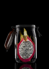 A glass storage or canning jar isolated on black with reflection, with lid open.