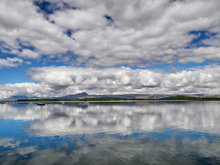 Clouds reflection in water background. Beautiful cumulus clouds reflected in the lake, nature...