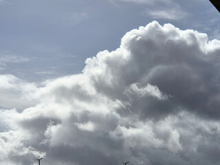 Summer white fluffy cumulus clouds in the deep blue sky