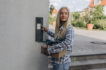 Drone delivery delivering parcel package. UAV drone deliver give to female costumer in front of...
