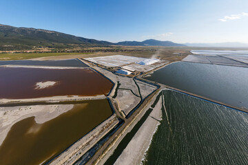 Extracting salt from open salt evaporation ponds, aerial wide shot