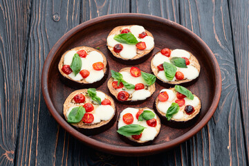 Italian mini pizza . Aubergine (eggplant ) with mozzarella cheese and basil . On rustic background