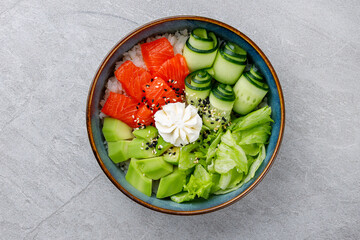 Hawaiian salmon poke bowl with avocado, Top view, gray background