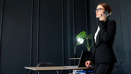 Confident and successful middle-aged businesswoman working in her modern office. Ideal for themes of leadership, success, and professional achievements.