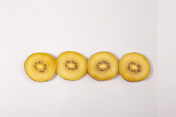 Slices of gold kiwi on white background.