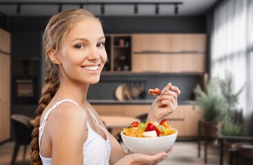 Athletic young woman eating a fruit bowl