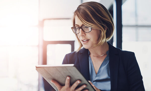 Business woman, research and reading with tablet for news, data or study on corporate development at office. Young female person or employee with glasses on technology for company overview or report