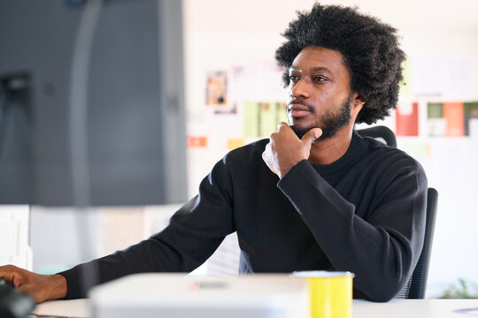 Man looking thoughtful at computer screen