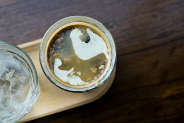 Dirty coffee iced Mocha freeze milk pour espresso shot in a cup of coffee on wood tray at cafe