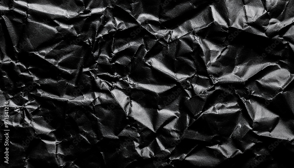 Poster textured black wrinkled paper. close-up of crumpled black fabric material with intricate fold patter