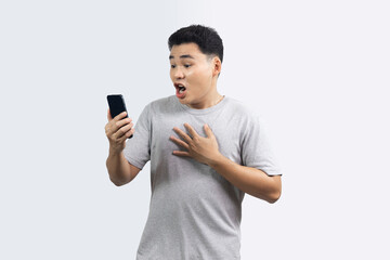 Portrait of excited man looking smartphone and hand on his chest isolated on white background