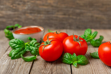 Fresh cherry tomatoes and fresh green basil on a textured background. Tomato sauce. Vegan. Ingredients for salad. Organic food. Place for text. Copy space.