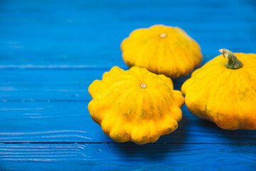Pattypan zucchini on a textured kitchen table. squash. Fresh organic pattypan squashes on...