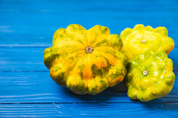 Pattypan zucchini on a textured kitchen table. squash. Fresh organic pattypan squashes on...