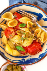 Summer pasta Conchiglie with baked tomatoes with feta cheese and aromatic herbs seasoned with extra virgin olive oil, basil, olives. Summer Mediterranean lunch, Greek and Italian light cuisine