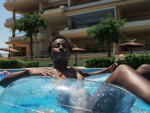 Peaceful woman relaxing on floater in pool