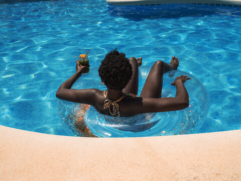 Anonymous woman relaxing on floater in pool