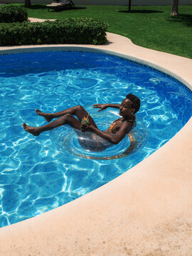 Serene woman floating on water donut in pool 