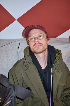 Man in a green jacket and glasses looks up
