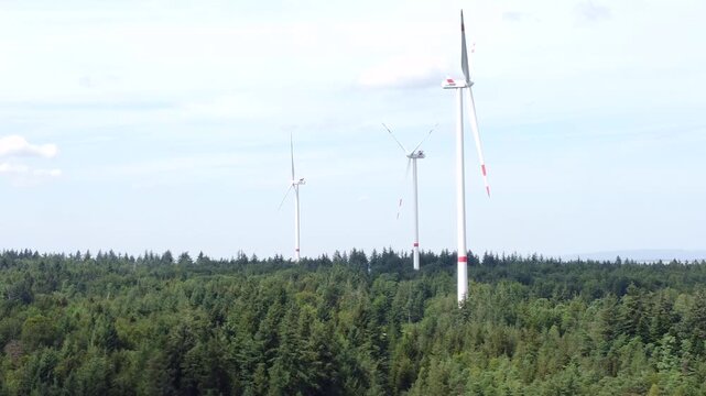 Drohne fliegt &uuml;ber Wald mit Windkraftanlagen bei Windstille, Alternative Energie, Energiewende, Luftaufnahme