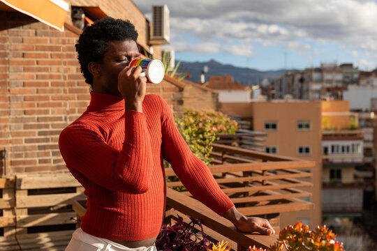 young non-binary boy on the balcony of his house