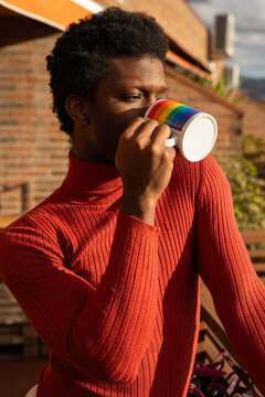 young non-binary boy on the balcony of his house