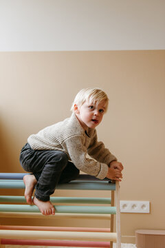 Child playing in a climber pikler triangle