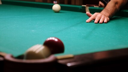 Russian billiards on a green table. American billiard. The player hits the red ball with a cue and...
