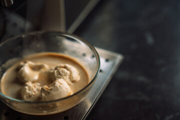 Ready-made dessert affogato ice cream poured with hot coffee in a glass cup.