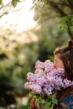girl smelling lilacs