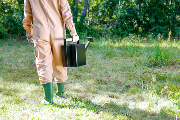 Woman farmer holding a black watering can. Sunny autumn day in the garden. Autumn gardening and...