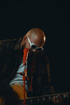 Man Playing Guitar with Orange Microphone and White Sunglasses