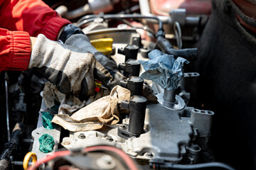 A close-up shot focuses on the gloved hands of a mechanic working