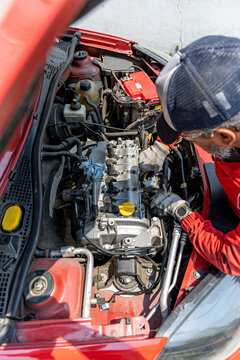 Man with automotive knowledge works on repairing his car's engine