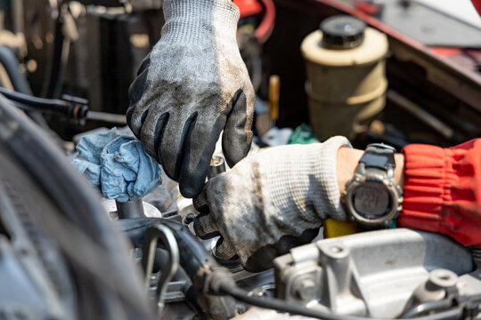 A mechanic using a special tool to remove the spark plugs from his car