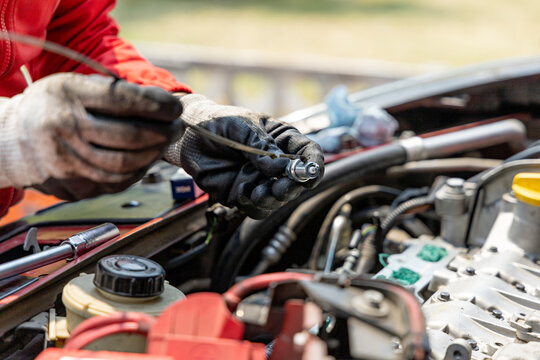 Close-up of the hands of a mechanic oiling a new spark plug