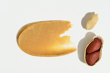 Smear of peanut butter and whole nuts in shell on white isolated background. Concept of breakfast...