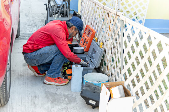 Man sifts through his gear boxes seeking out a tool to repair his car