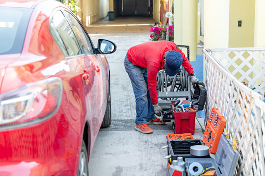 An adult man searches for a special tool to repair his car