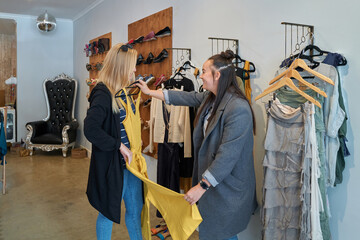 Lesbian couple shop together in small independent fashion store