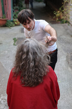 50 years old gentleman fixing woman hair in street